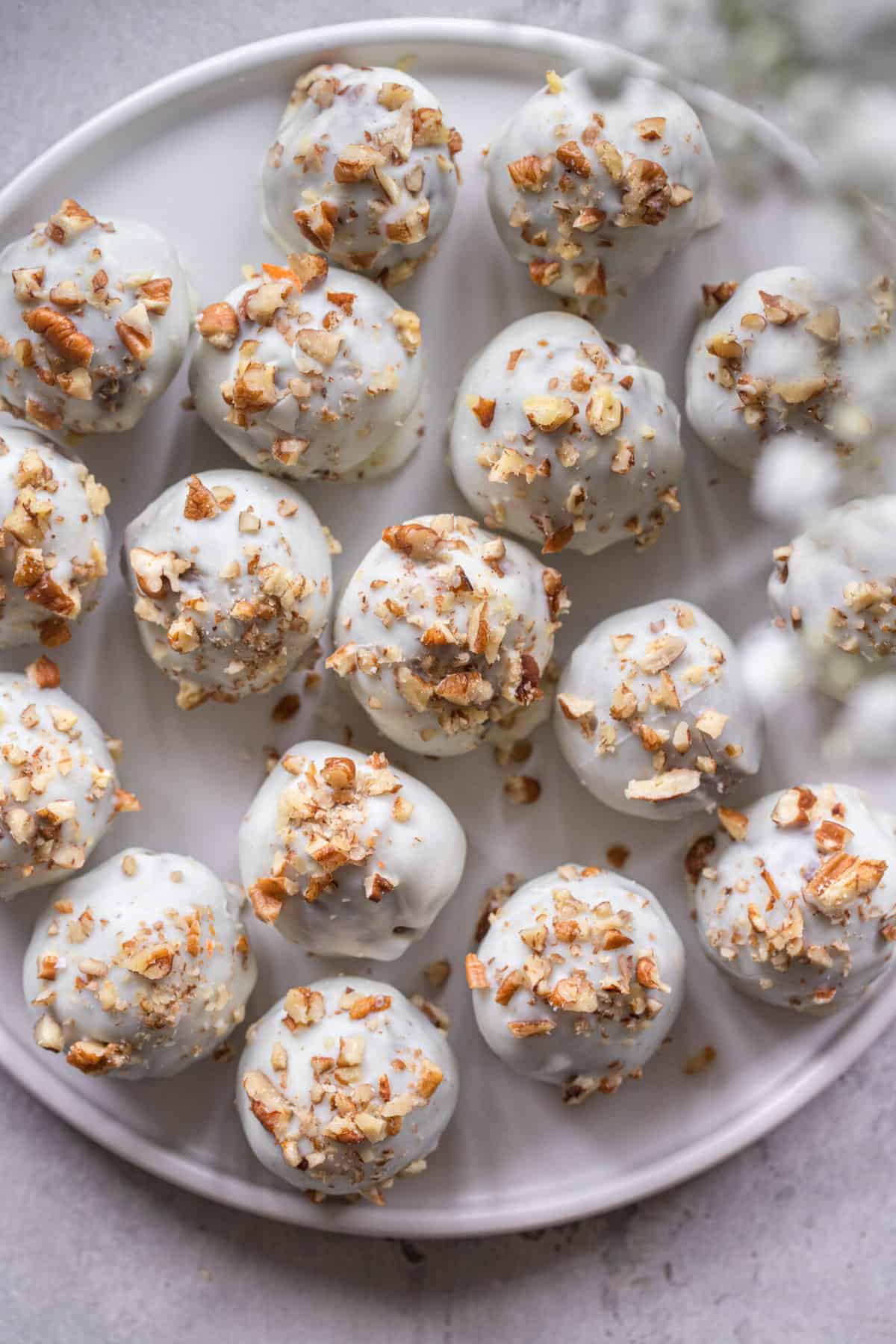 Gluten Free Carrot Cake Truffles - These Gluten Free Carrot Cake Truffles are soft on the inside with a crunchy, sweet candy coating. You'll never know these cute little bites are only 50 calories and better for ya! | #Foodfaithfitness | #glutenfree #carrotcake #healthy #easter Carrot Truffles recipe overhead view on a plate