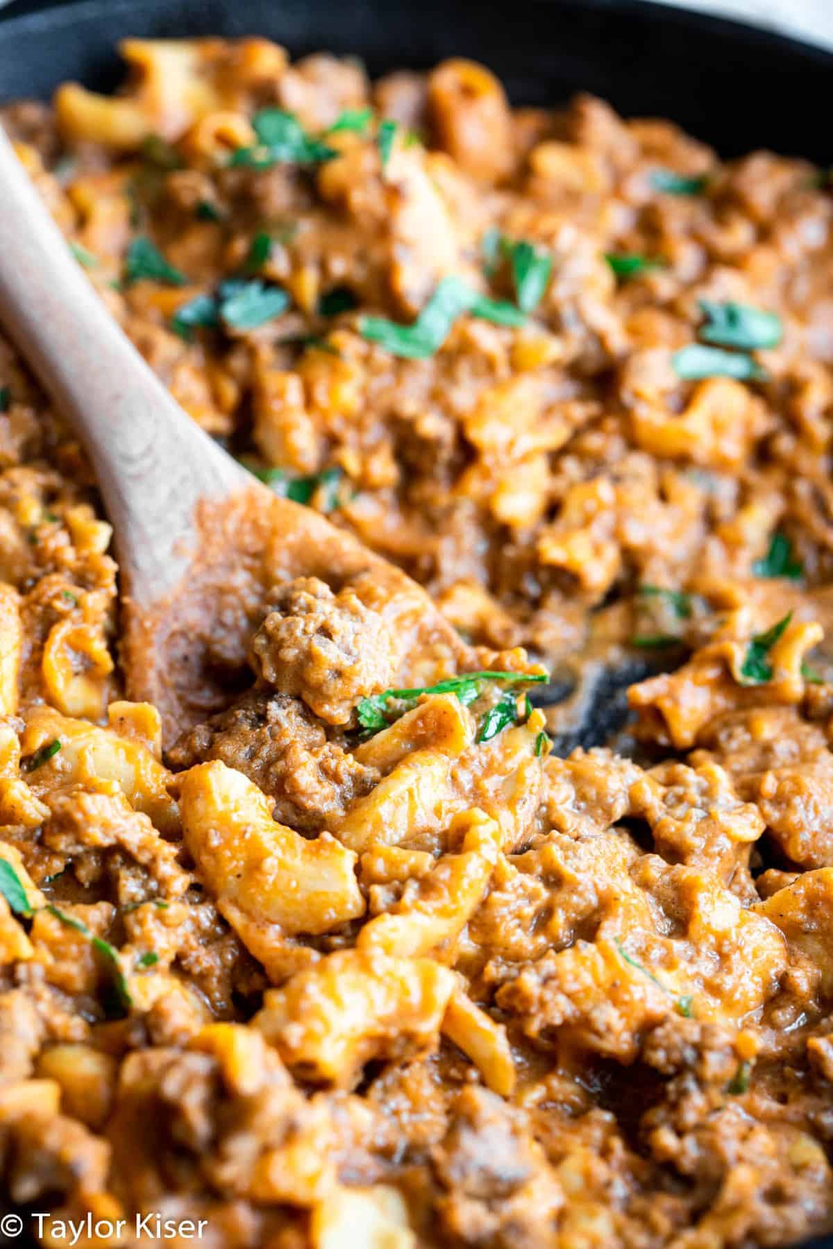 Gluten Free Homemade Healthy Hamburger Helper - A quick and easy, 30 minute meal for busy weeknights! A remake of the boxed version that is naturally gluten free, protein packed and has a dairy free option! Even picky eaters will love it! | #Foodfaithfitness | #Glutenfree #dairyfree #healthy #easydinner #easymeals DIY hamburger helper in a skillet with a spoon