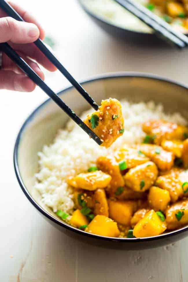 Mango Chicken with Coconut Cauliflower Rice - This paleo mango chicken is served over coconut cauliflower rice for a quick, easy and healthy spin on take-out that is ready in 30 mins! Recipe has a vegan option too! | Foodfaithfitness.com | @FoodFaithFit