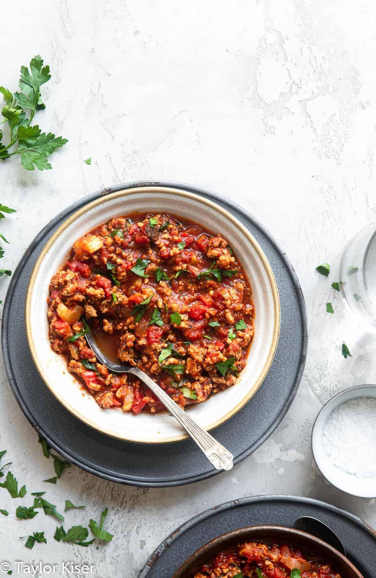 No Bean Low Carb Keto Turkey Chili - This Low Carb Keto Turkey Chili is healthy comfort food at it's best! An easy, weeknight dinner that will please the whole crowd! Gluten free, keto and paleo too! | #Foodfaithfitness | #keto #lowcarb #paleo #healthy #whole30 keto friendly chili in a bowl with parley