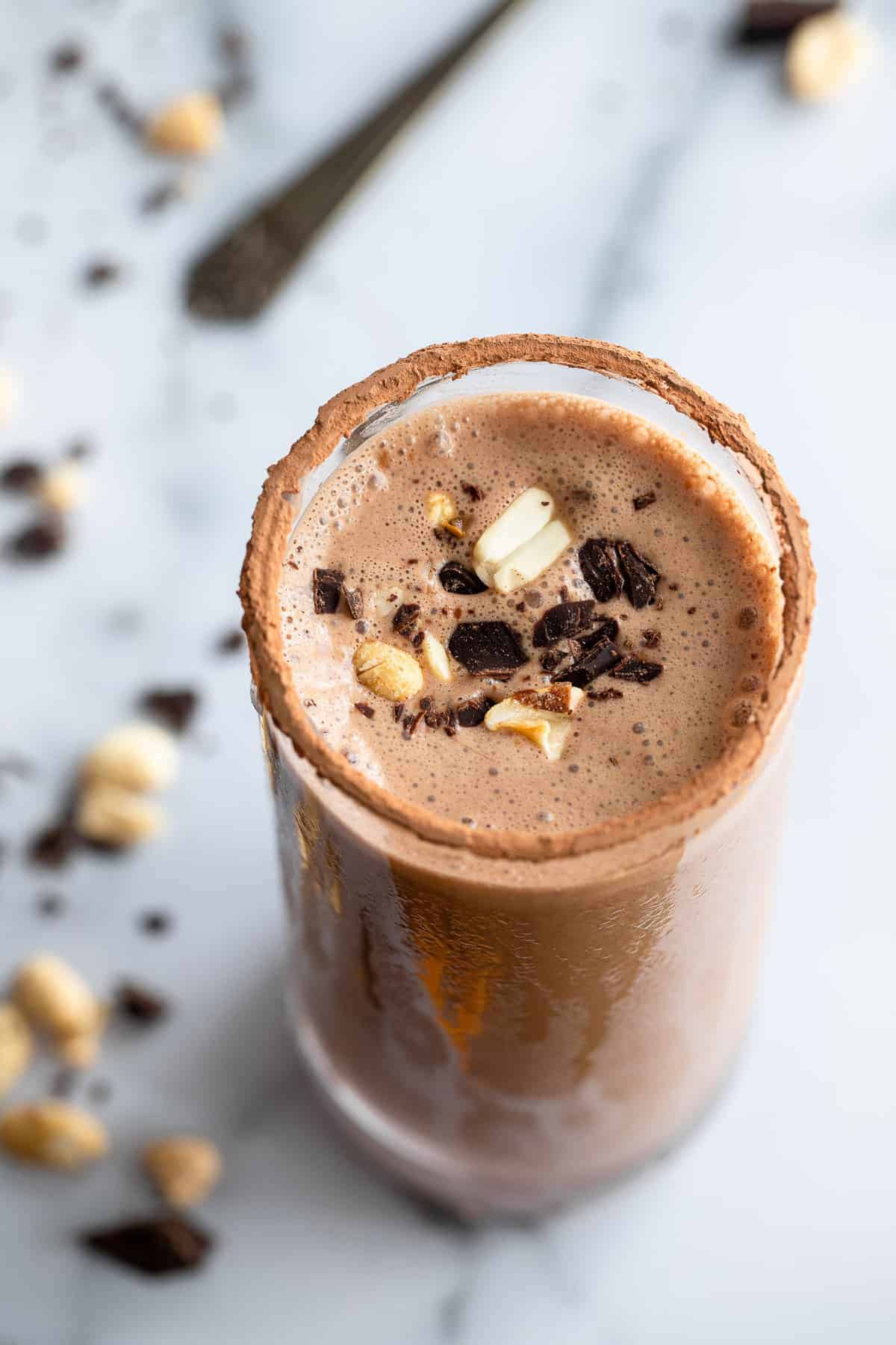 Chocolate Peanut Butter Protein Shake - A quick and easy protein Shake loaded with chocolate and peanut butter and NO protein powder! Perfect for a quick breakfast or snack! | #Foodfaithfitness | #glutenfree #dairyfree #healthy #breakfast Chocolate Protein Shake in a glass with peanuts on top