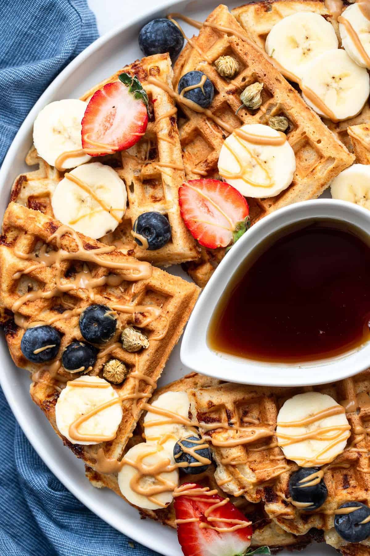 Easy Protein Waffles - These are the crispiest, fluffiest protein waffles you will ever eat! Naturally gluten free, quick, easy and so filling! A MUST MAKE. | #Foodfaithfitness | #glutenfree #healthy #waffles #breakfast protein powder waffles with strawberries on top